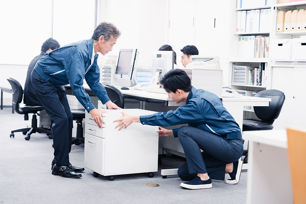 オフィス家具を設置する作業服の男性